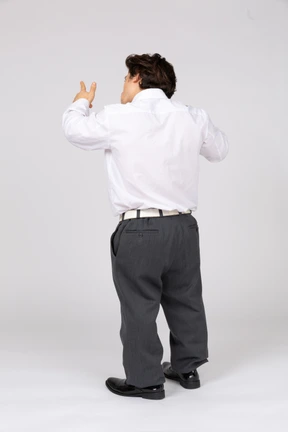 Vista trasera del hombre apuntando hacia arriba