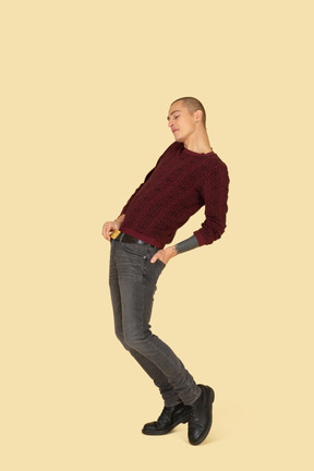 Vista posteriore di tre quarti di un giovane in pullover rosso appoggiato all'indietro
