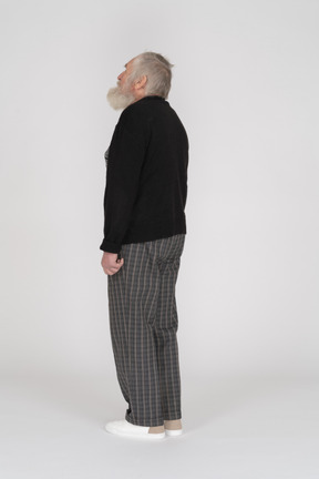 Three quarter back view of an old man looking up