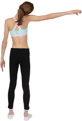 Vista traseira de uma adolescente em roupas esportivas esticando a mão e inclinando a cabeça