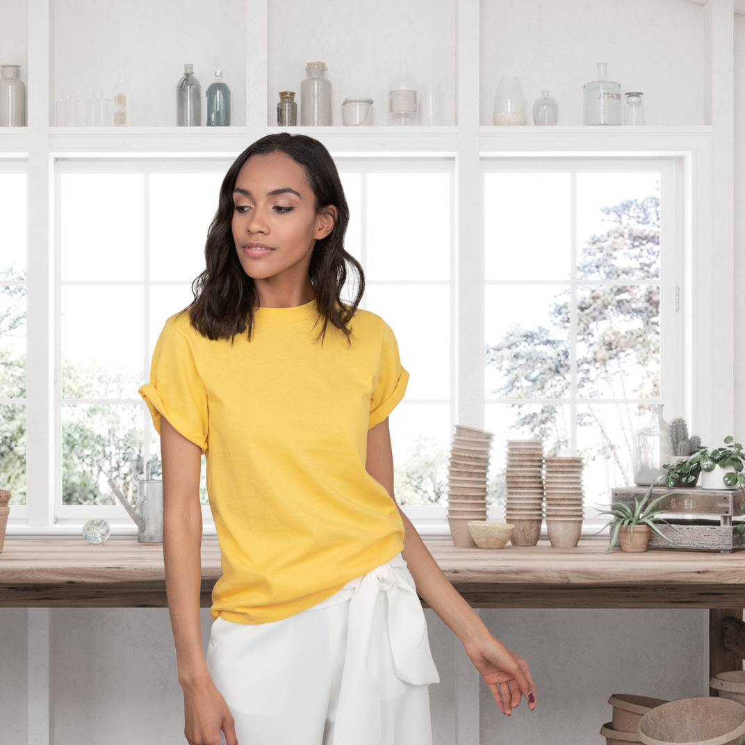 A woman in a white t shirt standing on a window sill