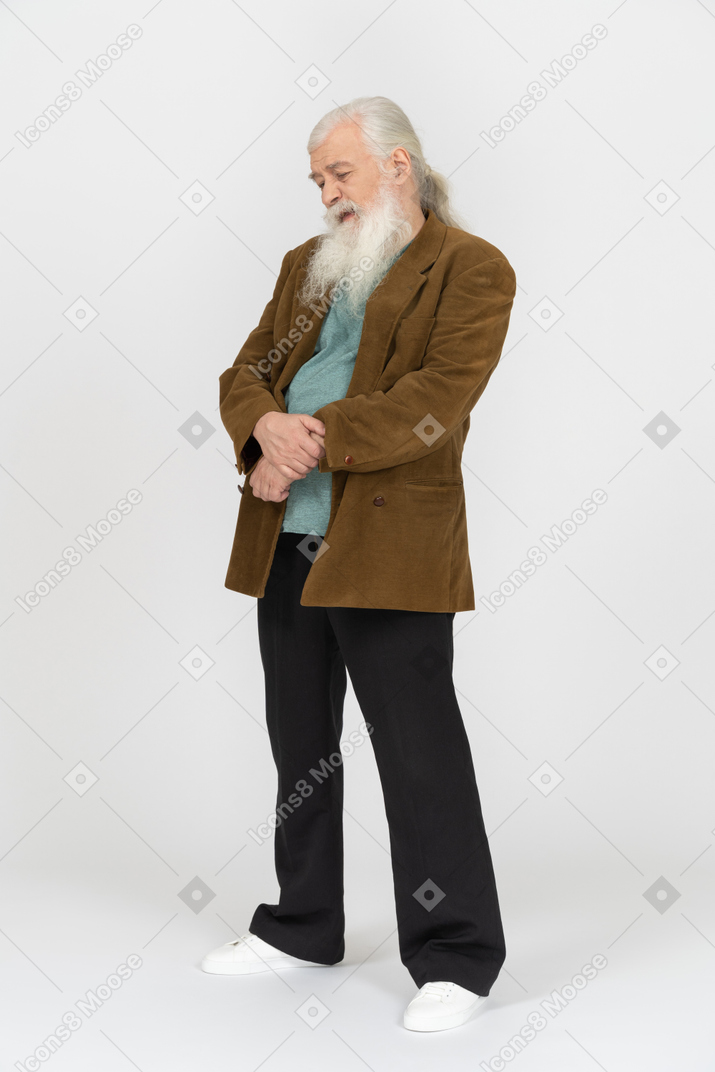 Elderly man clasping hands over stomach and looking upset