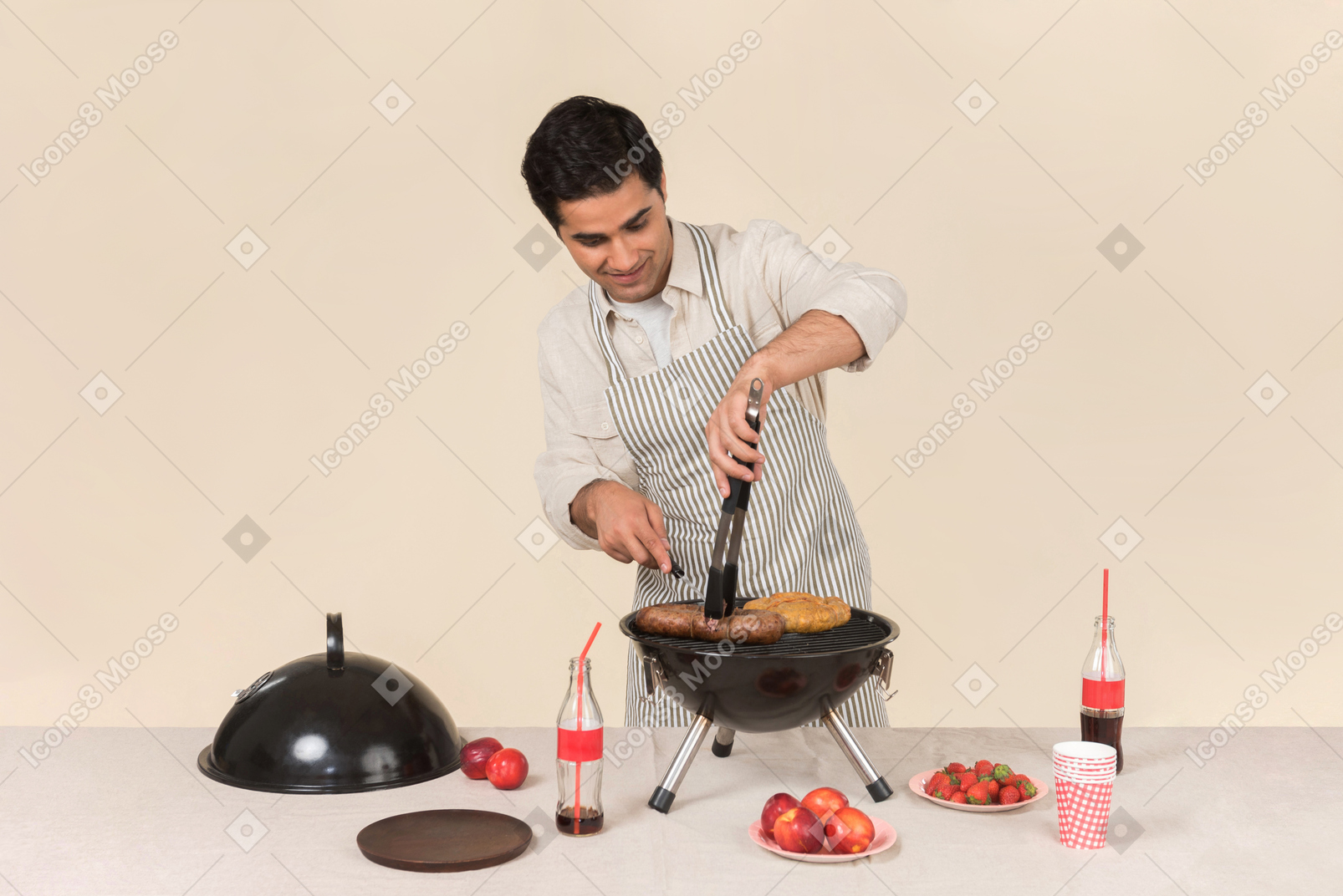 Jovem homem caucasiano focado em cozinhar churrasco