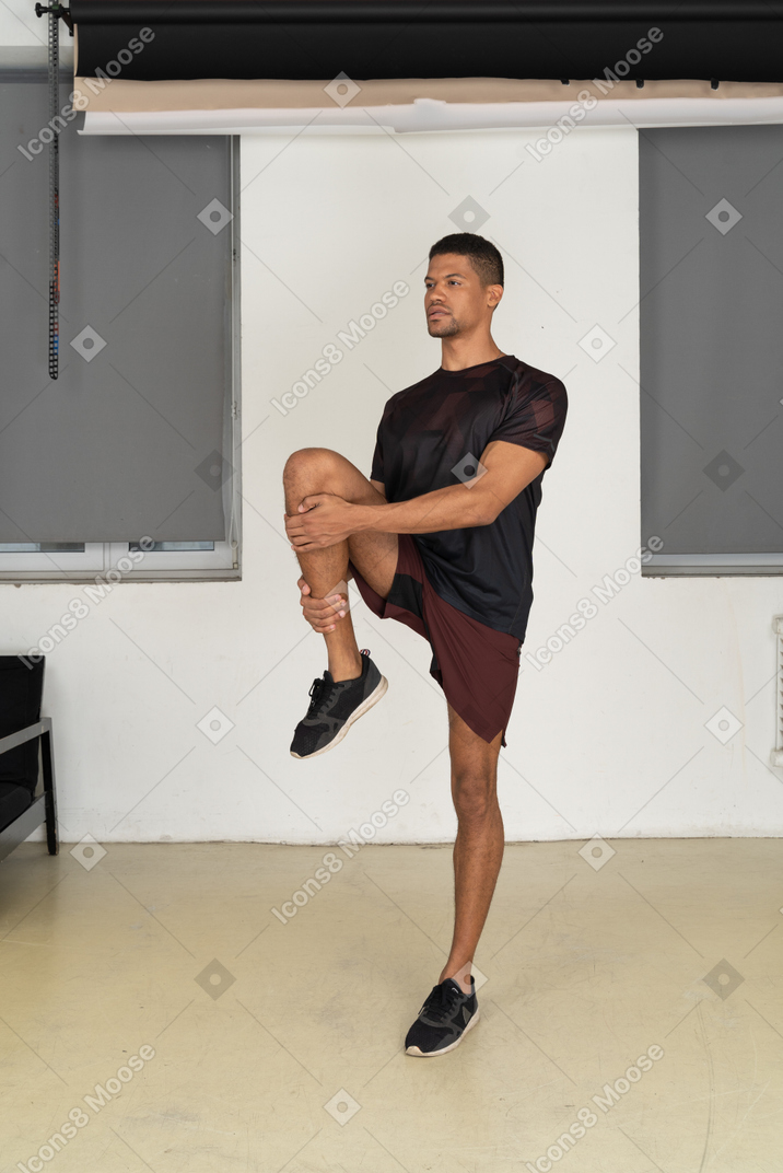 Young man in sports clothes stretching