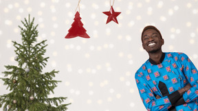 Happy man standing near the christmas tree