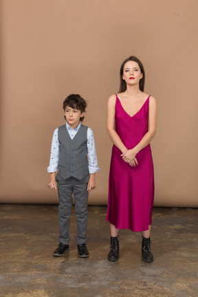 Young woman standing with a boy and smiling