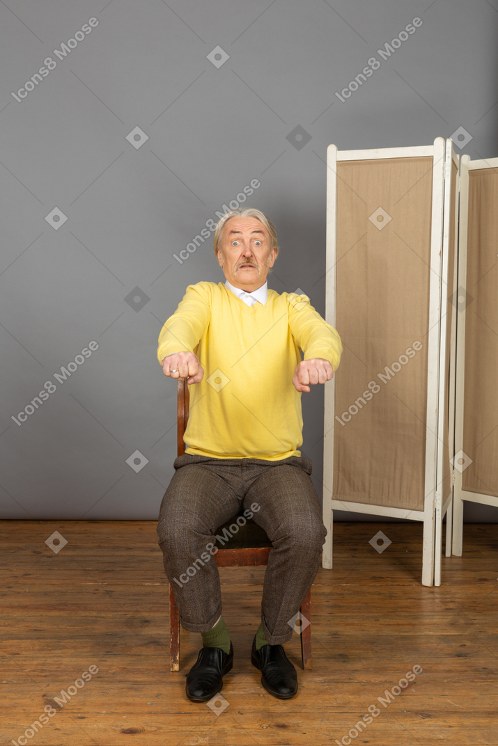 Shocked man clenching his fists and extending his arms forward