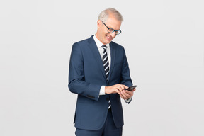 Элегантный мужчина средних лет, используя свой смартфон