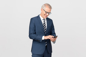 Elegant middle-aged man using his smartphone