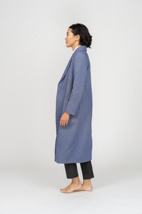 Back view of woman in coat barefoot