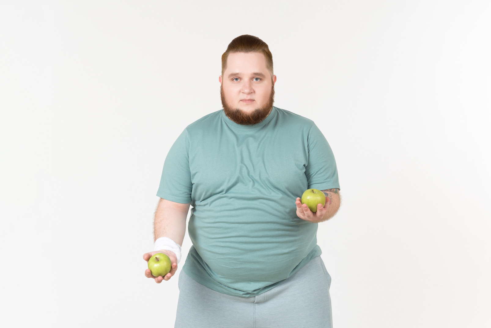 Young overweight man juggling with apples