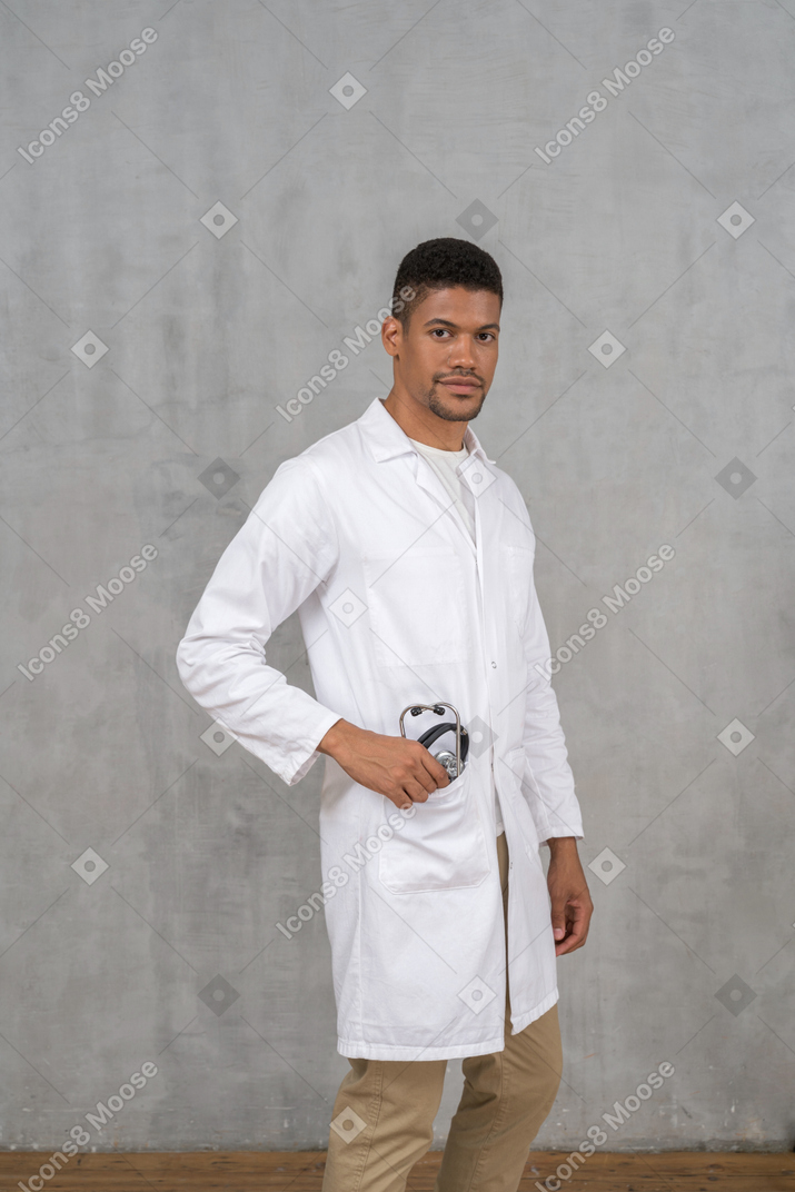 Médico varón poniendo su estetoscopio en el bolsillo