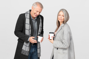 Homem brincando enquanto toma uma xícara de café com sua esposa