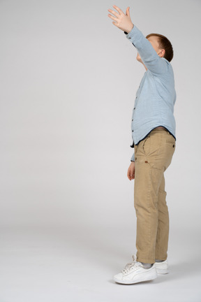 Side view of a boy pointing up with hand