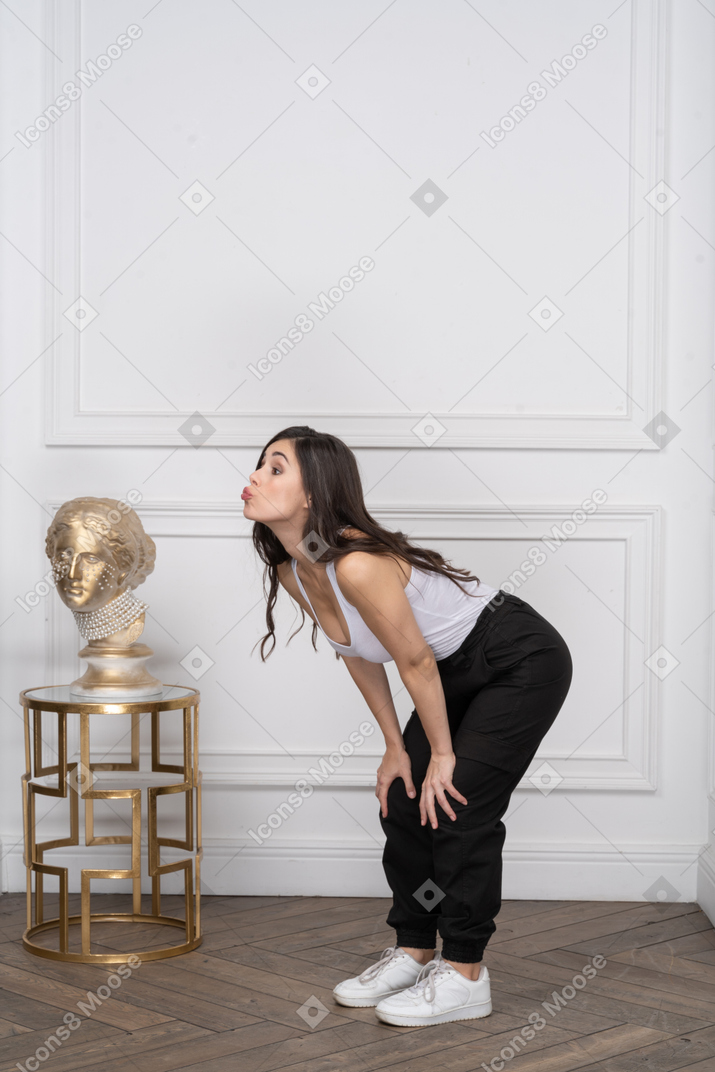 Young woman bending forward, making a silly face