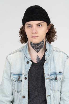 Portrait of a serious teenager wearing denim jacket and knit hat