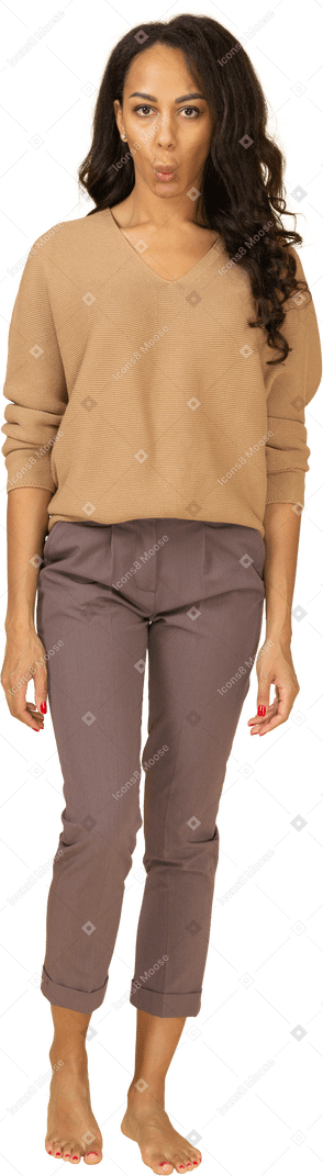 Vista frontal de una mujer joven sorprendida haciendo muecas en ropa casual