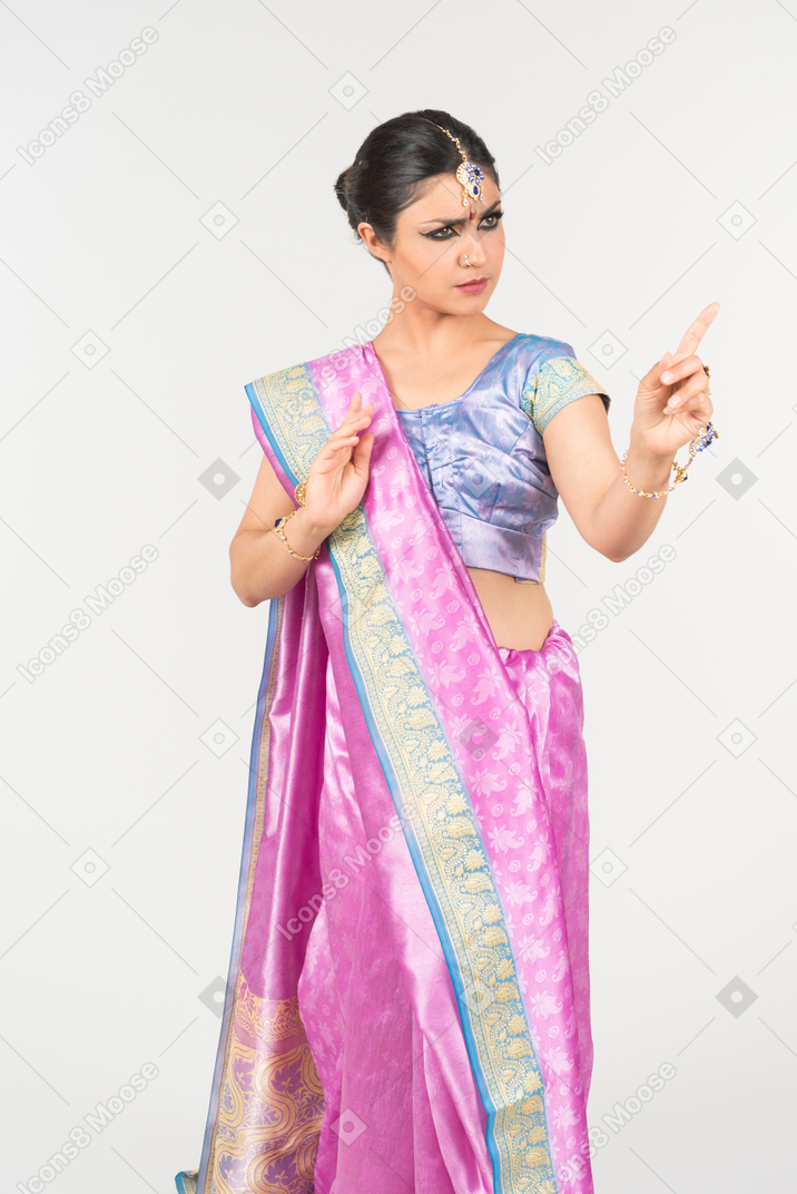 Безумно выглядящая молодая индийская женщина, указывающая вверх