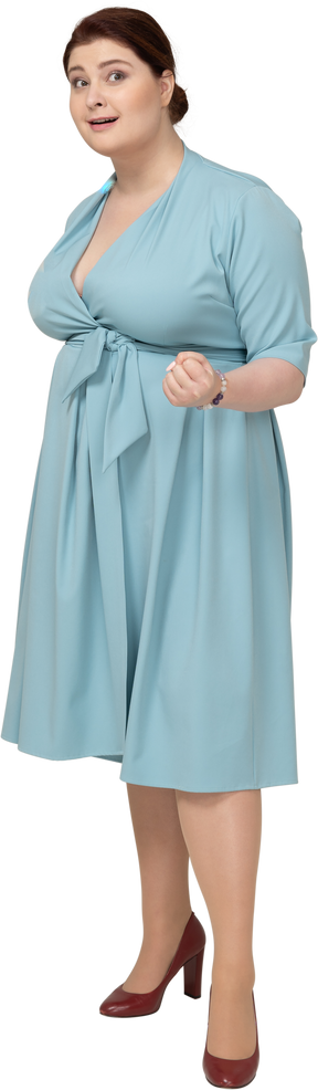 Vista frontale di una donna in abito blu che mostra un pugno