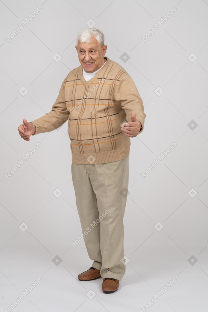 Vista frontal de un anciano feliz con ropa informal de pie con los brazos extendidos