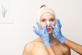 Female patient with hands putting plaster on her nose