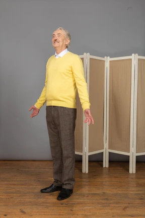 Three-quarter view of a surprised smiling old man looking up