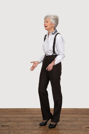 Three-quarter view of a crying questioning old lady outspreading her hands