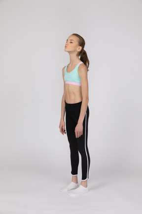 Side view of a teen girl in sportswear raising hand and arguing