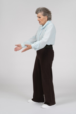Three-quarter view of an old woman gesturing questioningly