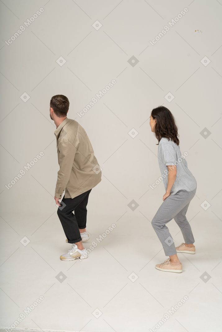 Three quarter back view of young man and woman exercising