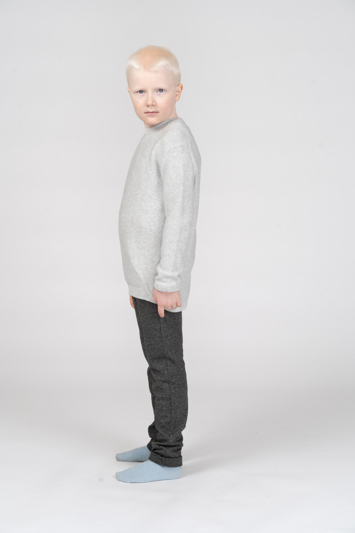 Side view of a kid boy  in casual clothes looking at camera