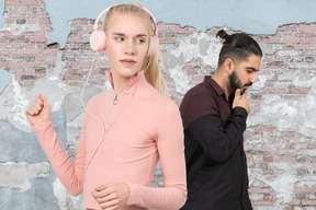 A man standing next to a woman with headphones on