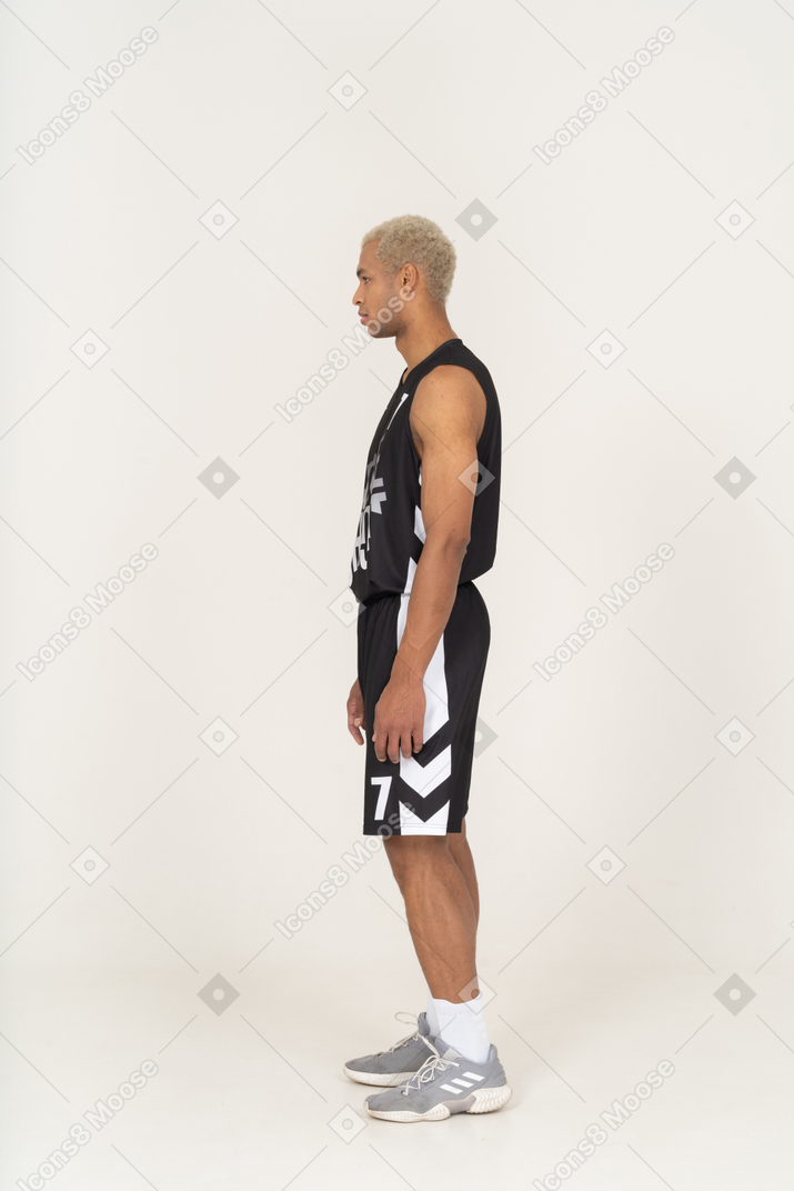 Side view of a young male basketball player standing still