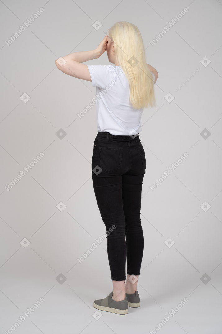 Vista traseira de uma mulher loira tocando suas têmporas