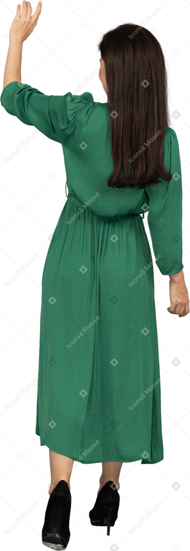 Вид сзади приветствующей молодой леди в зеленом платье