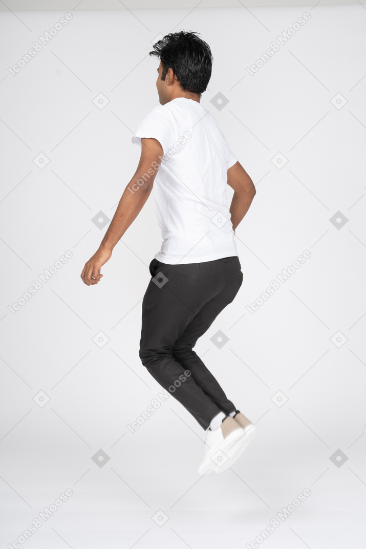 Человек в белой футболке прыгает