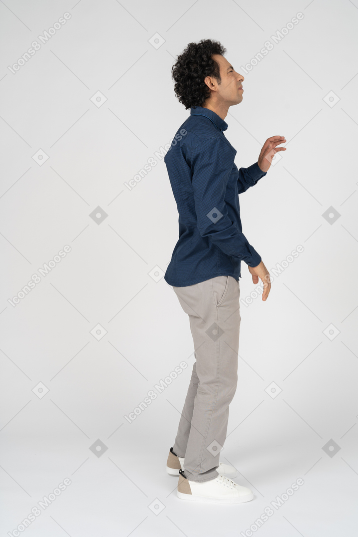 Side view of a man in casual clothes waving someone