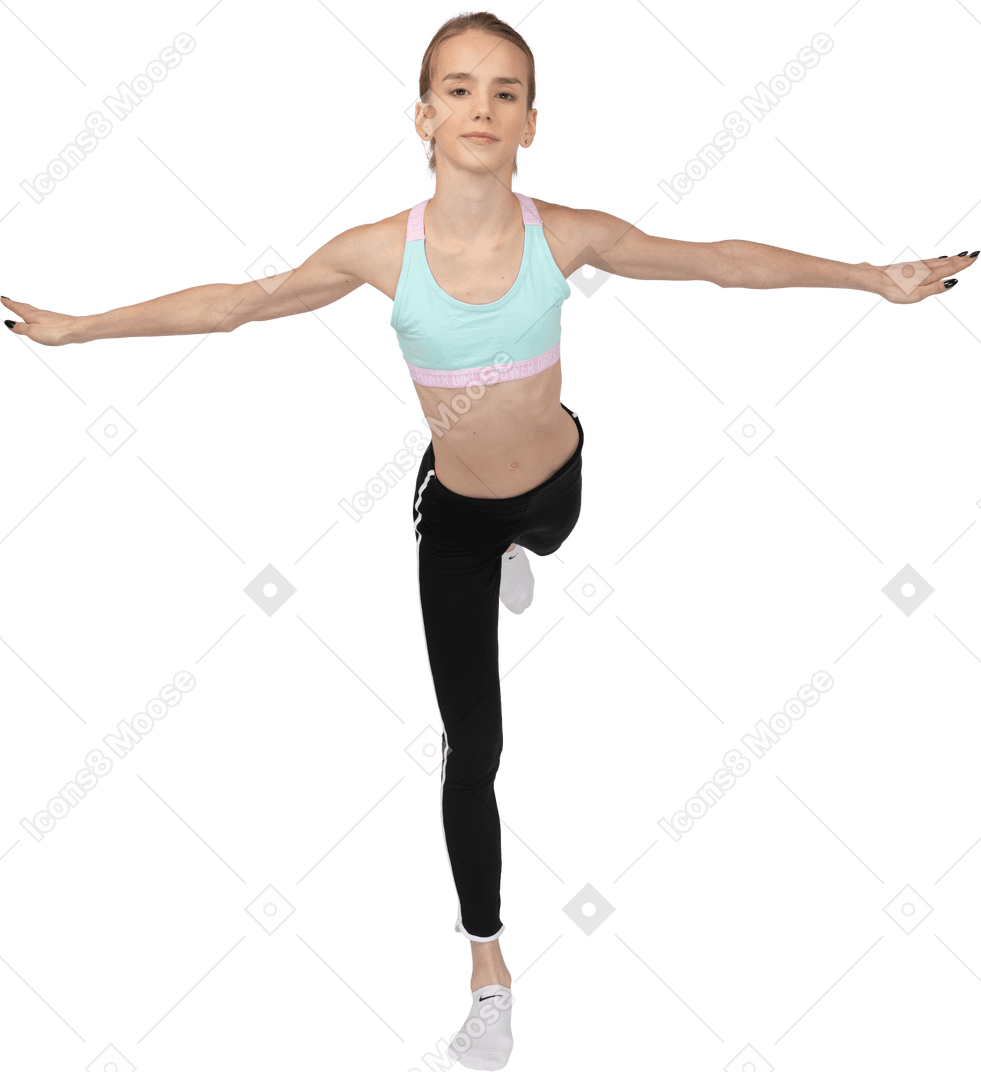 一个年轻的女孩，在她的腿上保持平衡的运动服的前视图