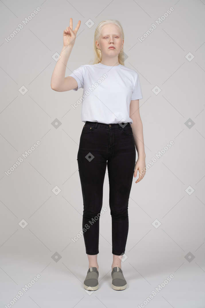 Young girl standing with v hand sign