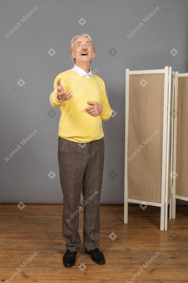 Front view of an inspired old man raising his hand