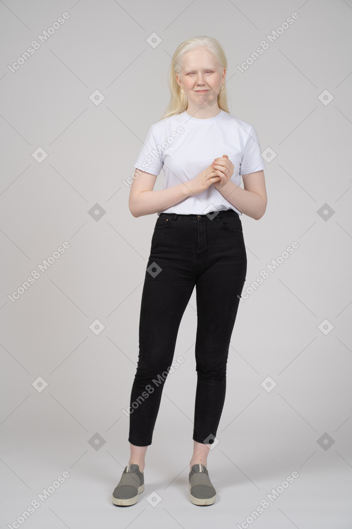 Young smiling woman in casual clothes folding hands