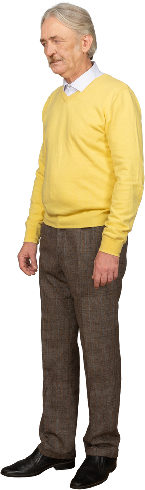 黄色のプルオーバーを着て脇を見ている不機嫌な老人の4分の3のビュー
