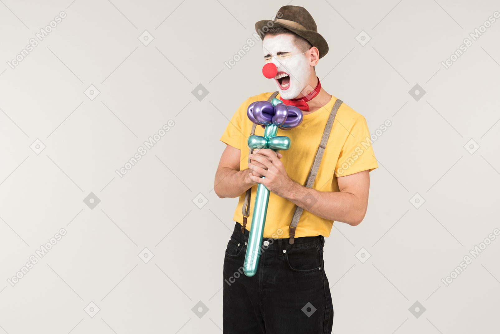 Male clown singing using balloon flower like a microphone