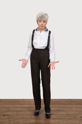 オフィス服で身振りで示す質問老婦人の正面図