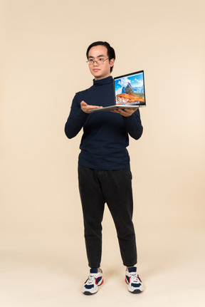 Young asian man presenting a laptop