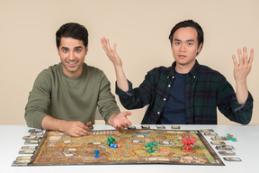 Amigos interraciales descubriendo algo mientras juegan juegos de mesa