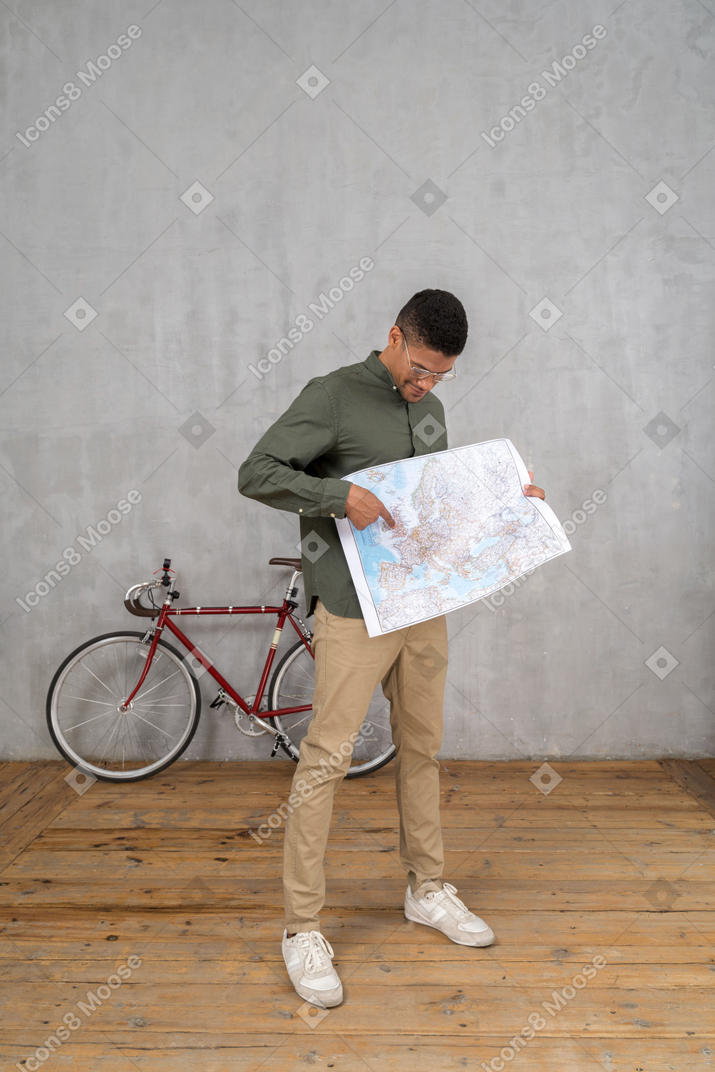 一个男人看着并指着地图的四分之三视图