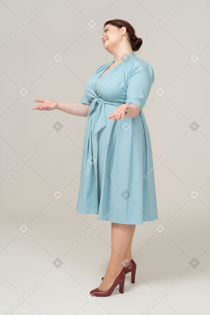 Side view of a woman in blue dress greeting someone