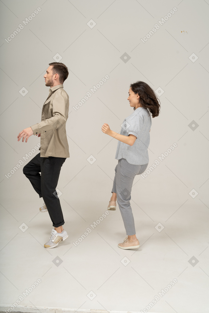 Vista lateral de homem e mulher dançando um ao lado do outro