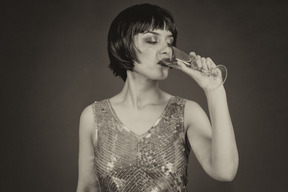 Black and white retro styled image of a woman drinking champagne
